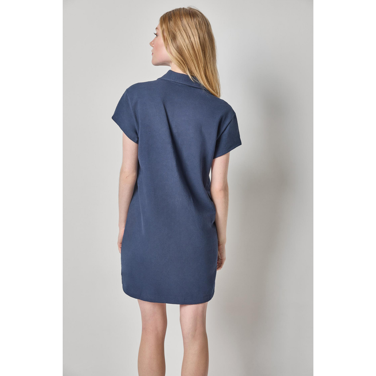 Woman wearing a blue dress against a plain background