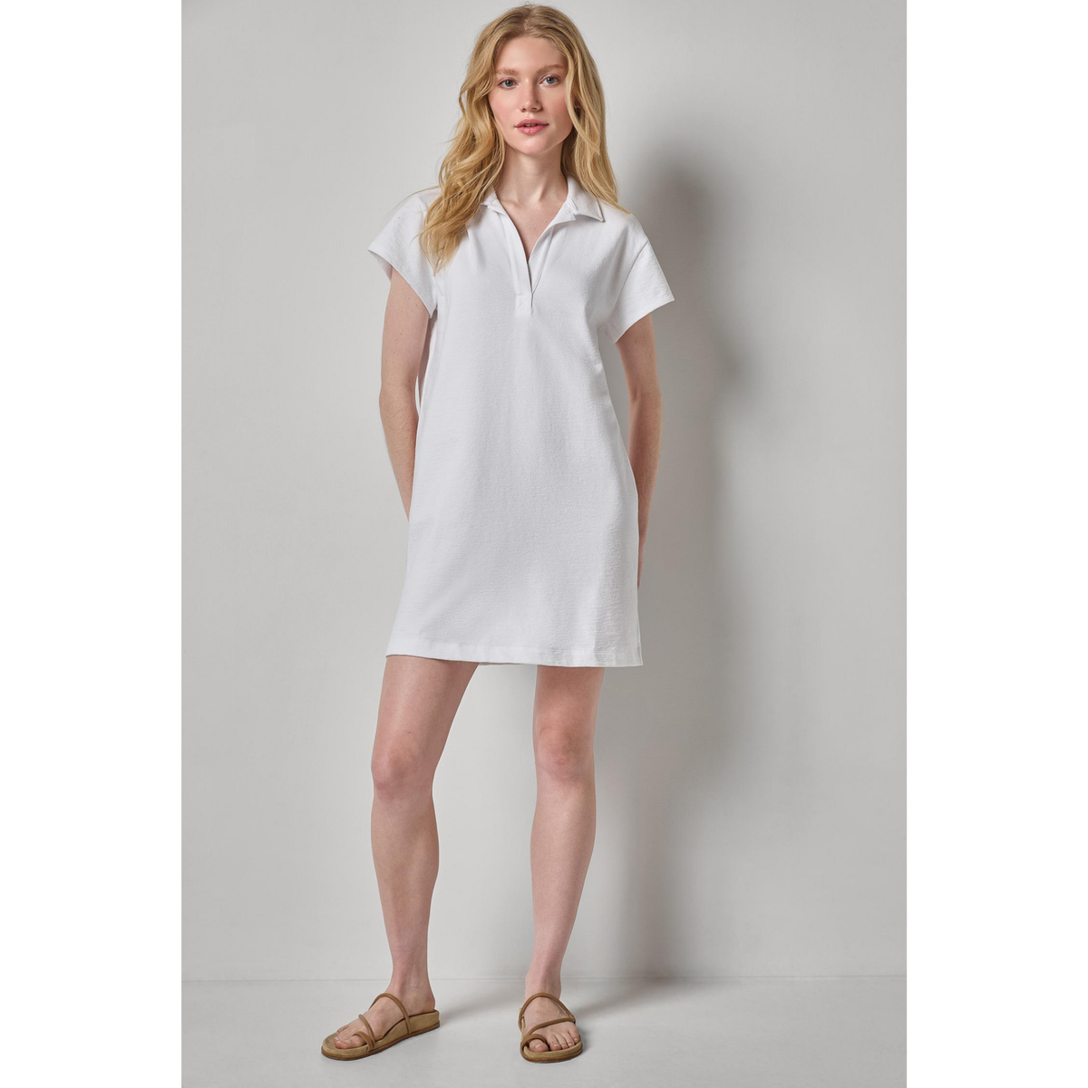 Woman wearing a white dress against a plain background