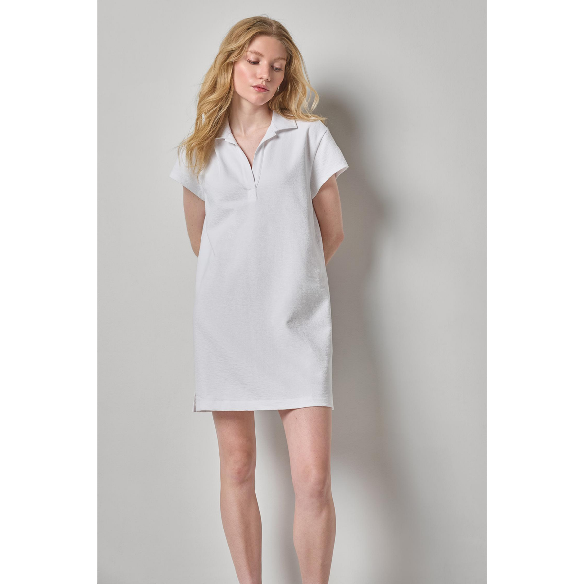 Woman wearing a white dress against a plain background