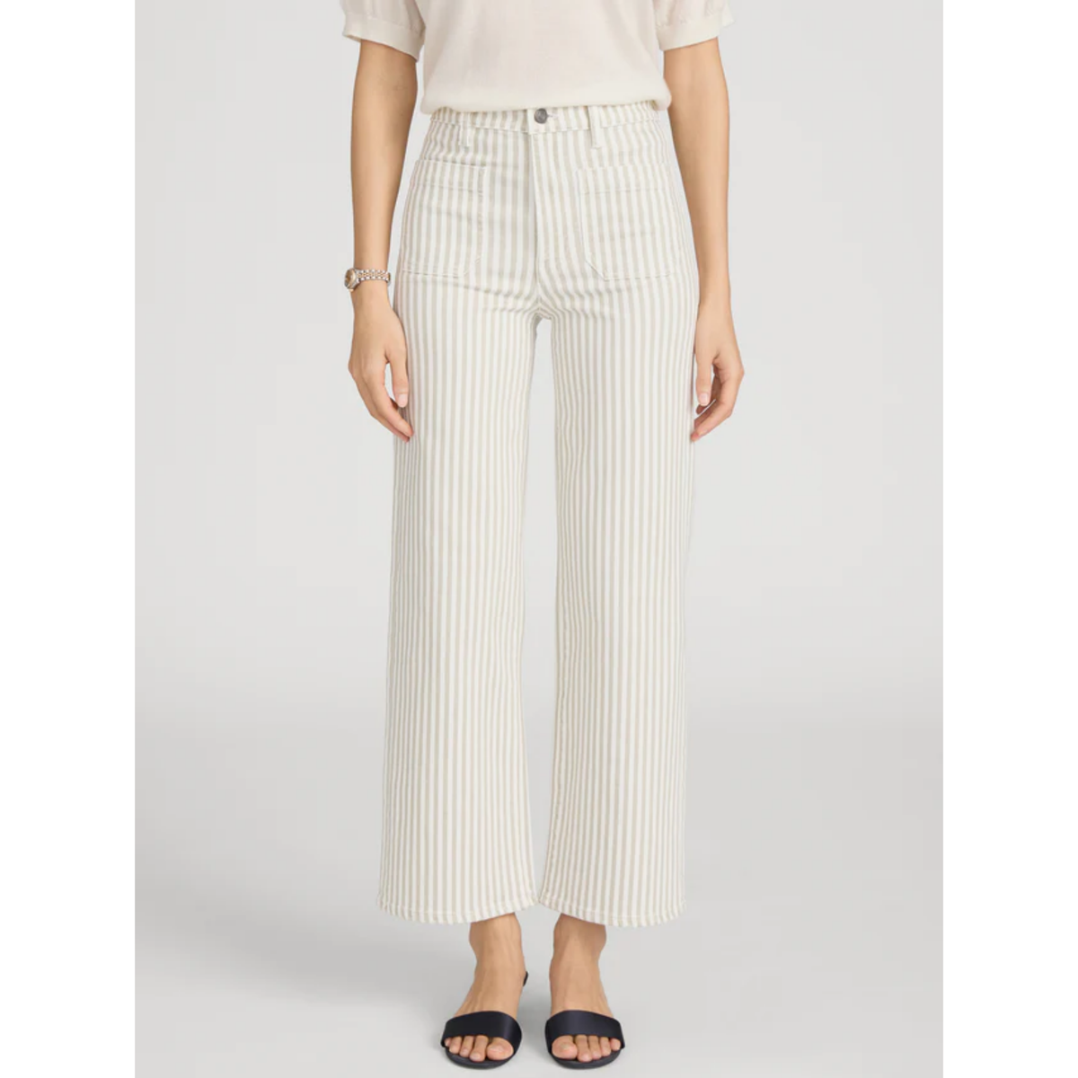 Person wearing white pleated pants on a plain background