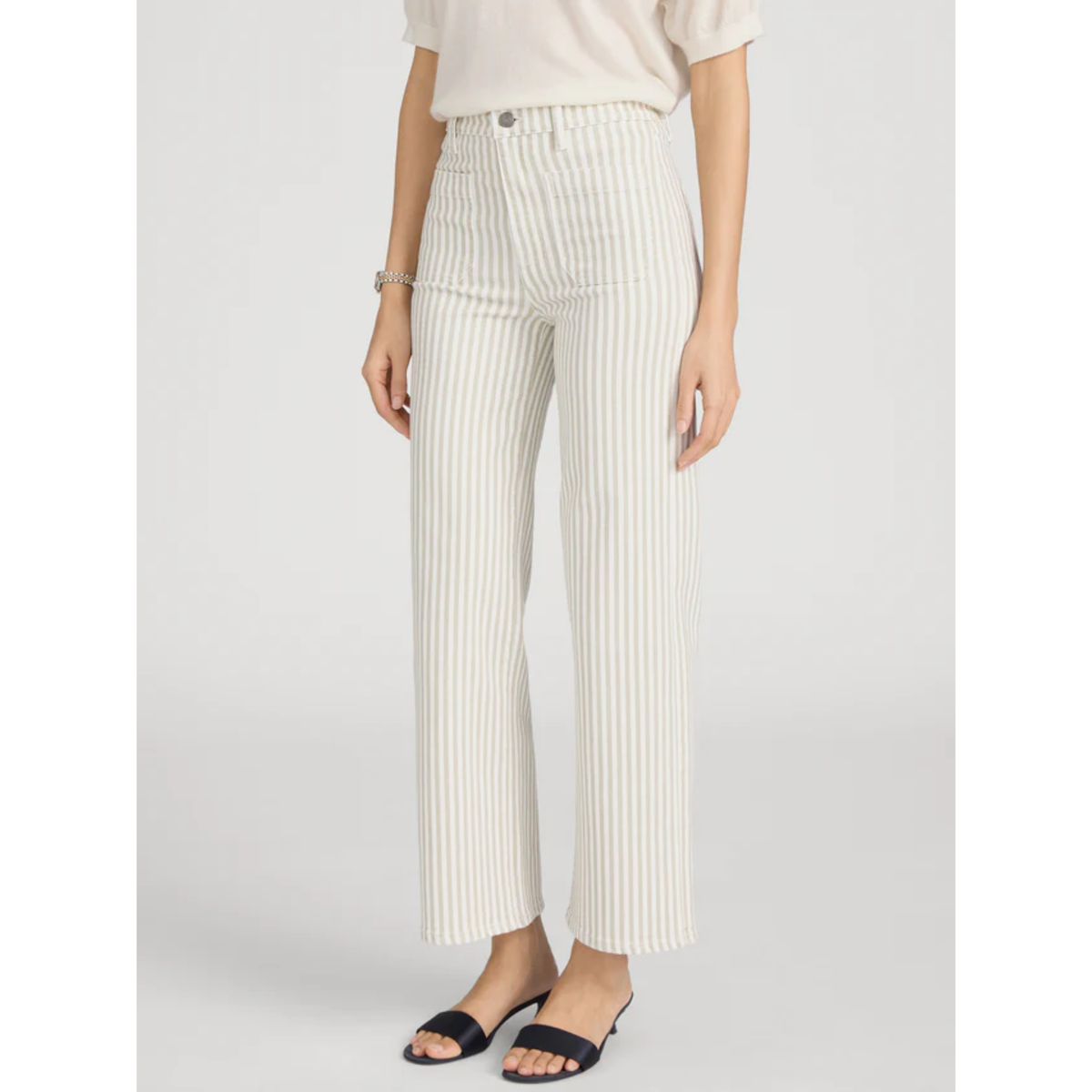 Person wearing white pinstripe pants on a plain background