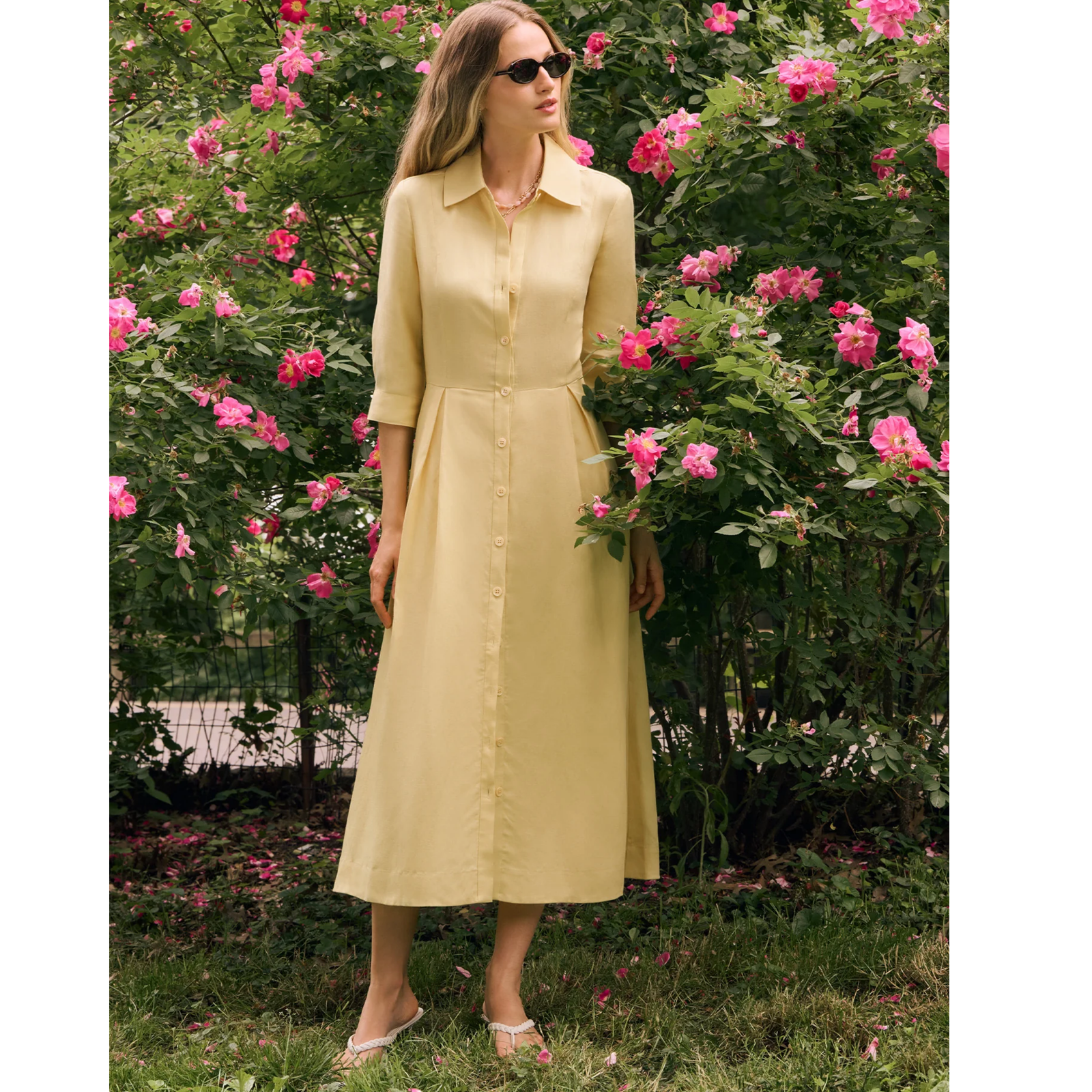 A pale yellow button-front midi dress with a pointed collar, 3/4 sleeves, and a gathered waist, shown on a plain light gray background.