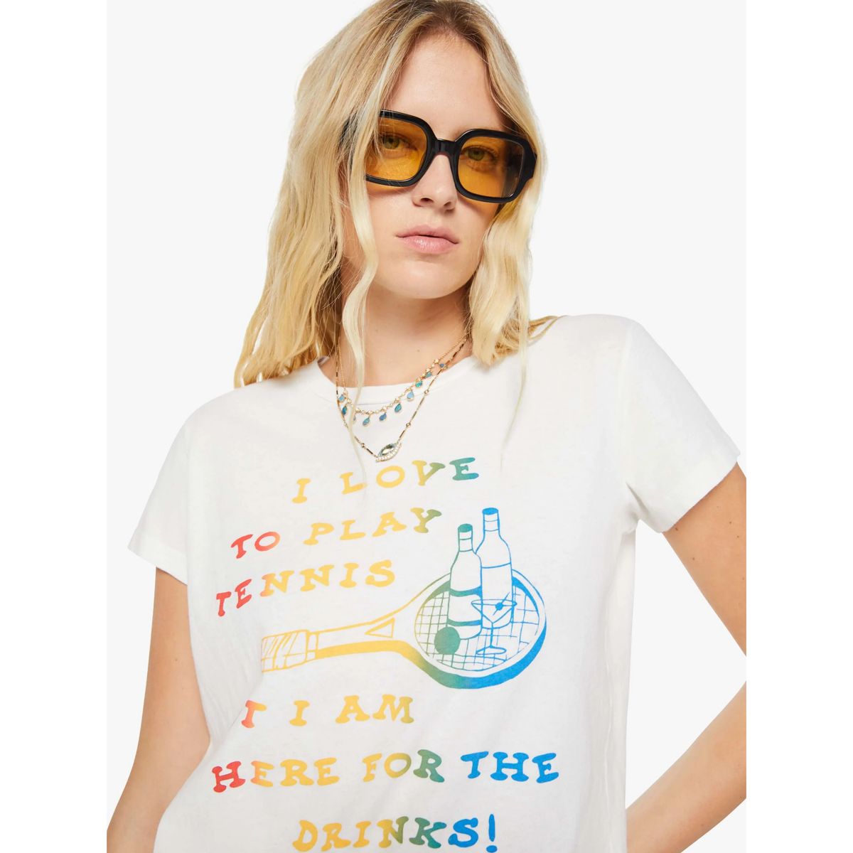 Person wearing a white t-shirt with colorful text and graphics, standing against a plain background.