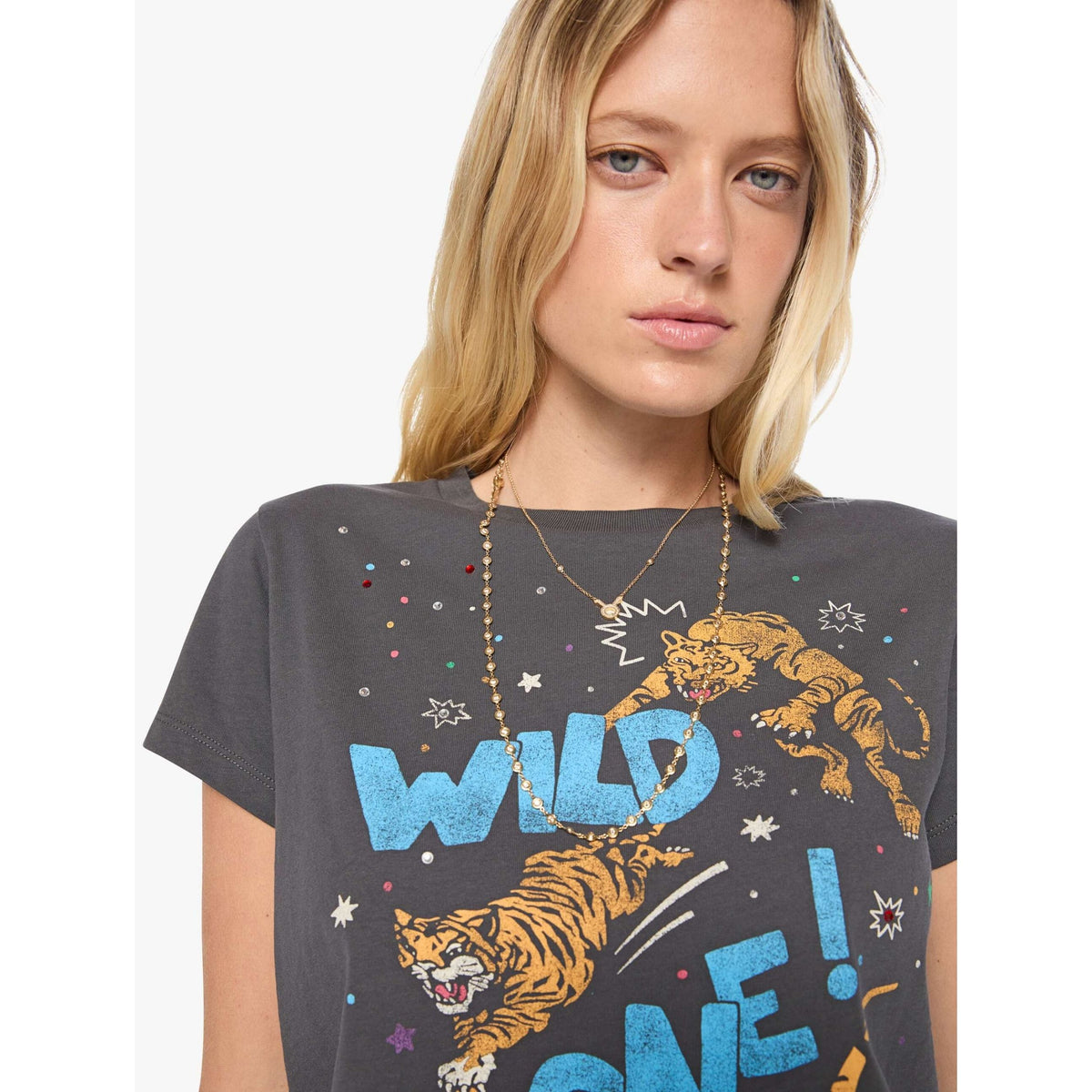 A woman wearing a dark gray graphic t-shirt with a colorful print of two lions and the text 'WILD LONE!'.