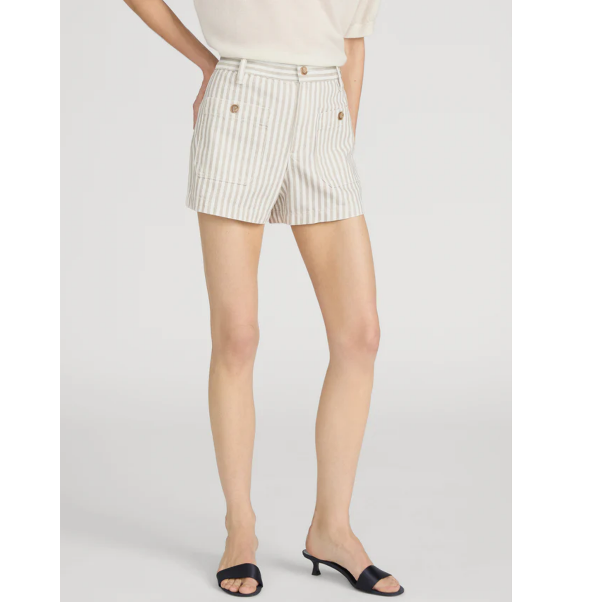 Person wearing white striped shorts on a plain background