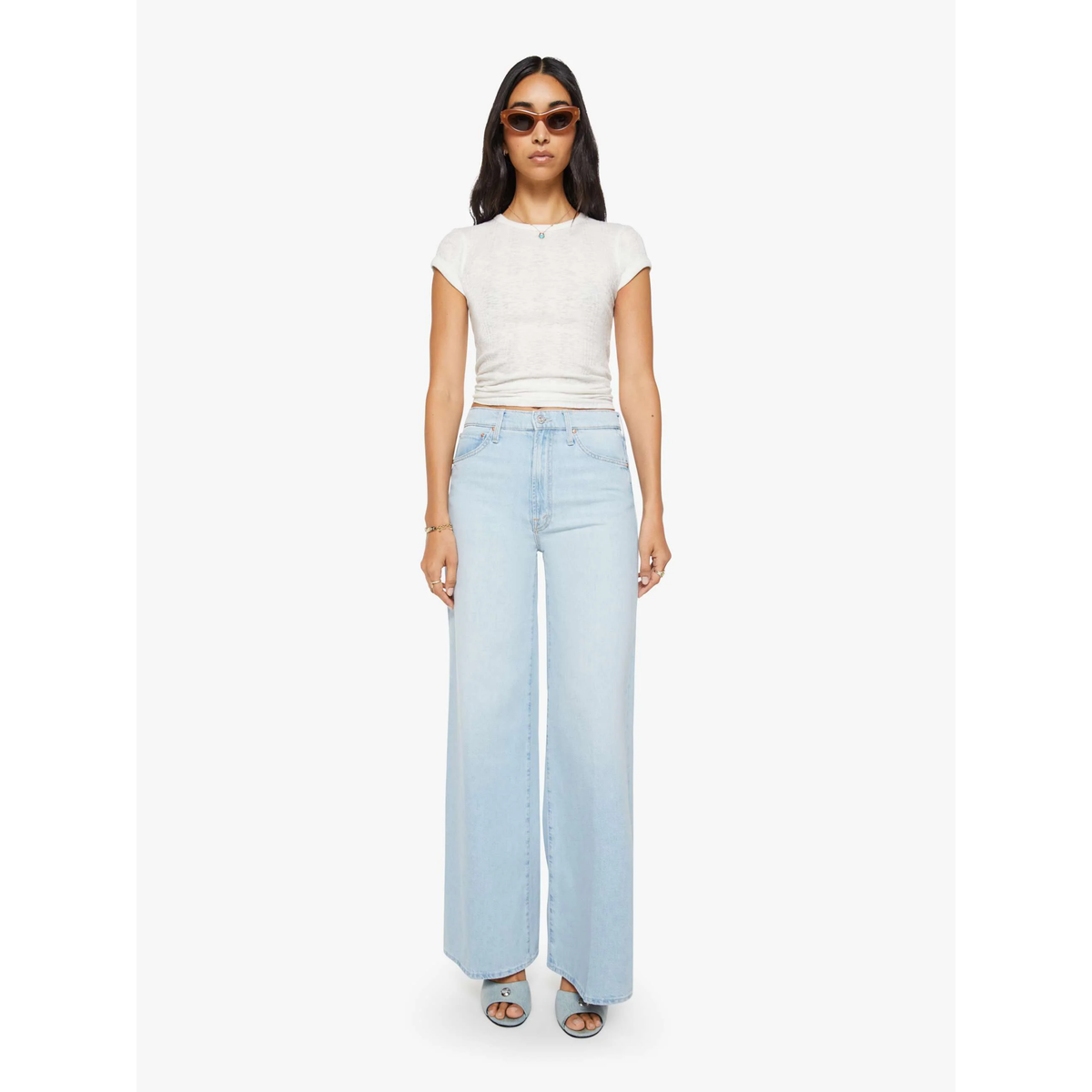 Woman wearing a white t-shirt and light blue jeans on a white background