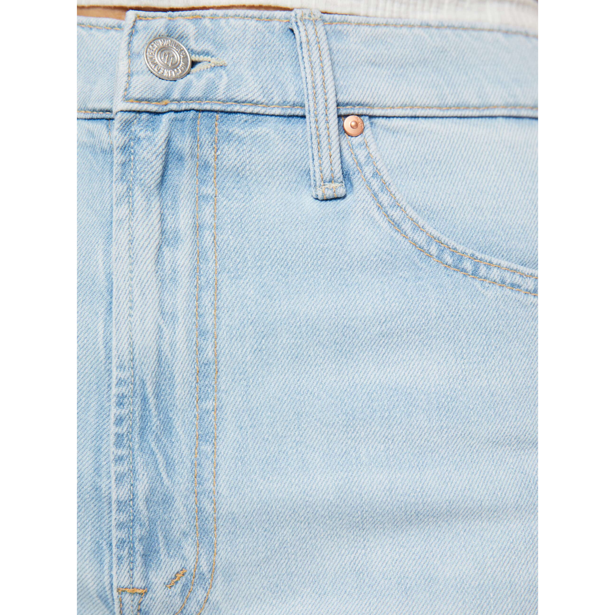 Close-up of light blue denim jeans with a brand logo on a white background