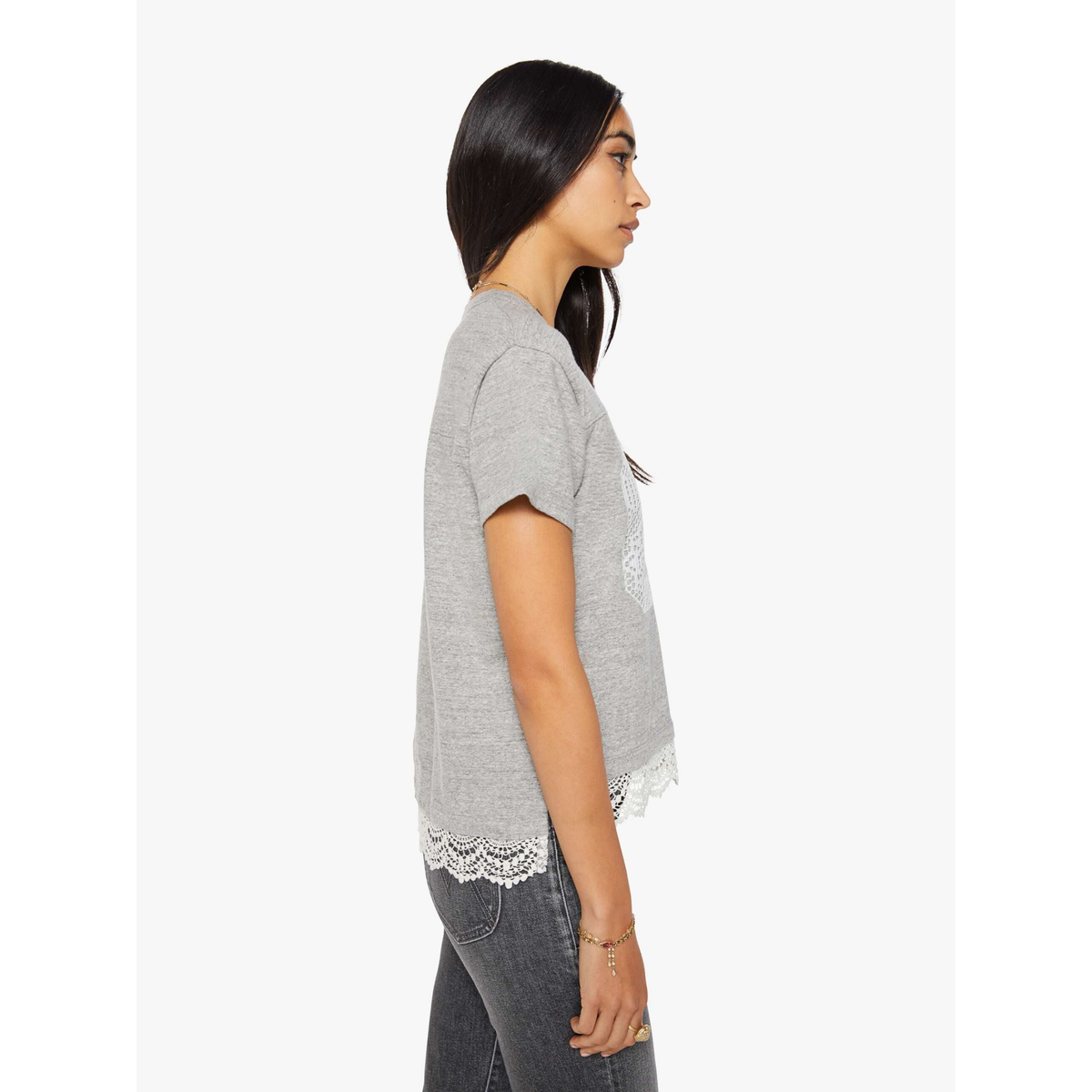 Woman wearing a gray t-shirt with lace trim on a white background