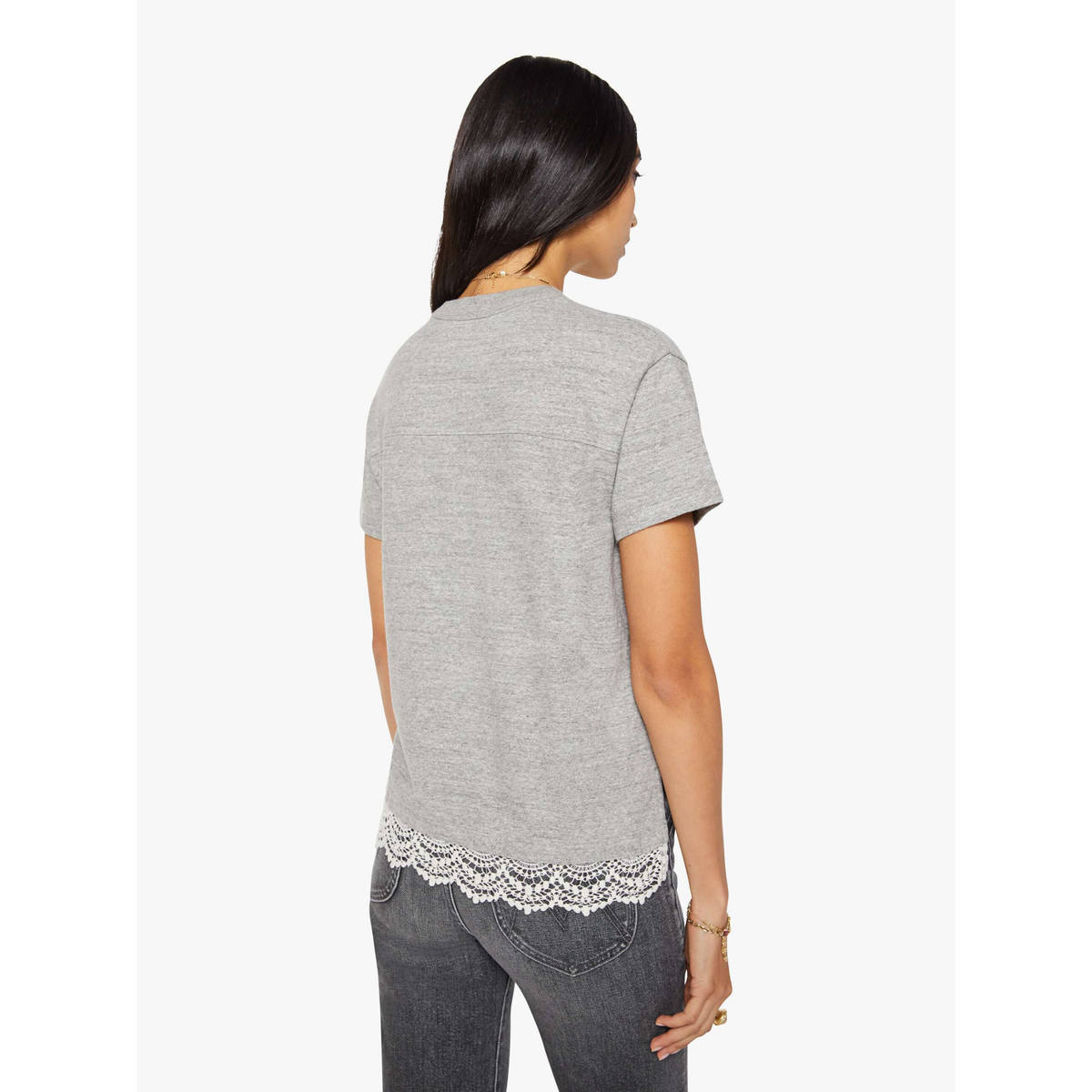 Woman wearing a gray t-shirt with lace trim on a white background