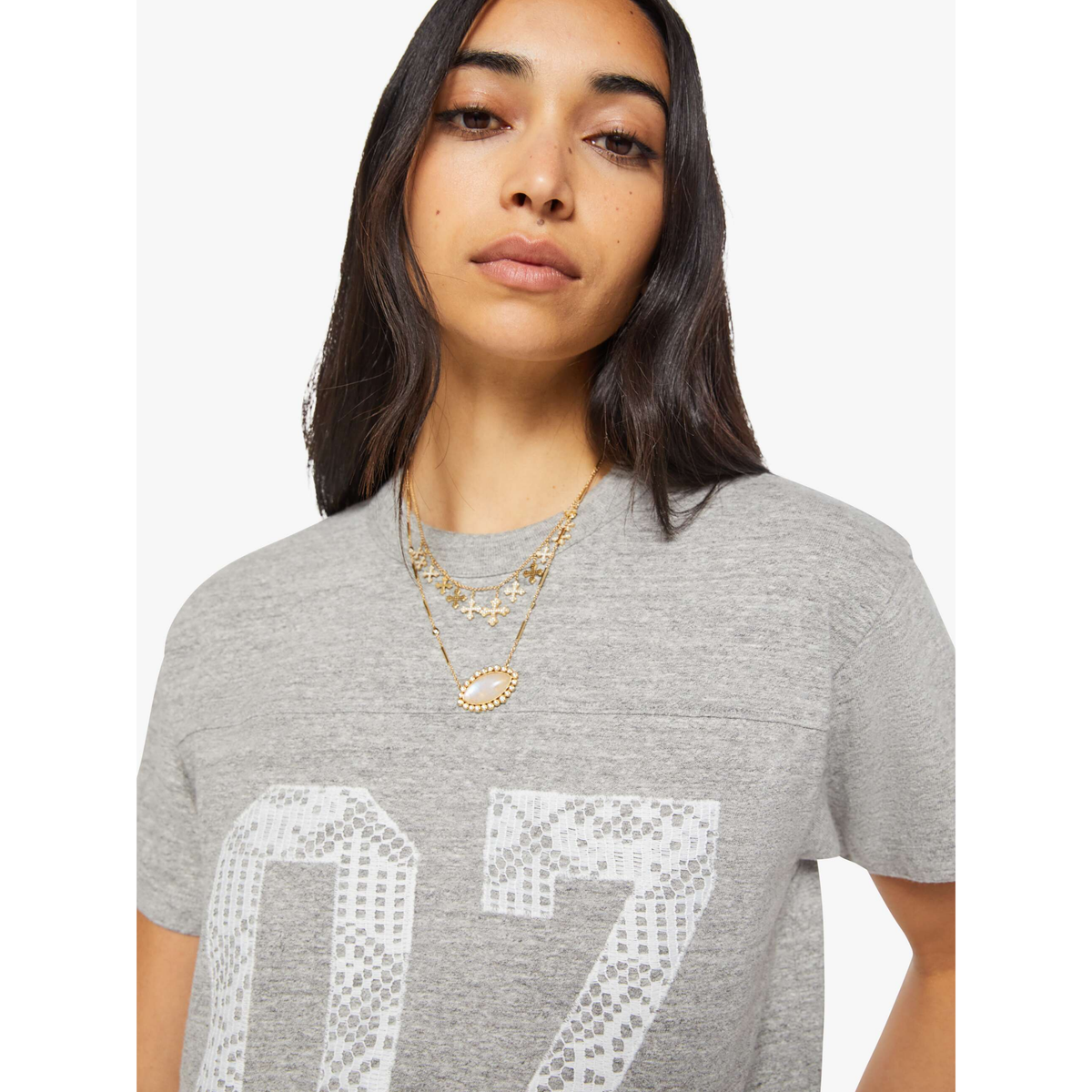 Woman wearing a gray t-shirt with '07' printed on it against a white background