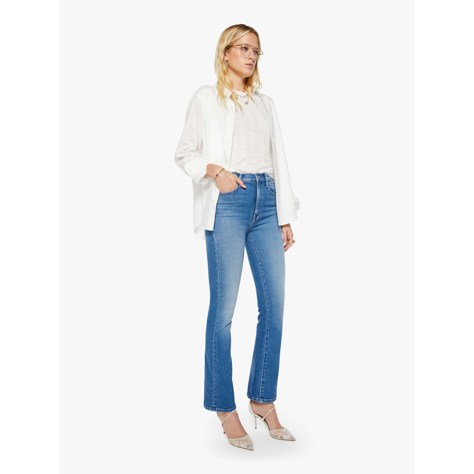 Woman wearing a white blouse and blue jeans on a white background