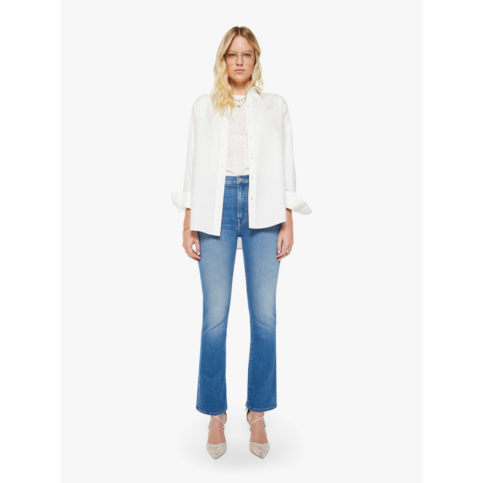 Woman wearing a white blouse and blue jeans on a white background