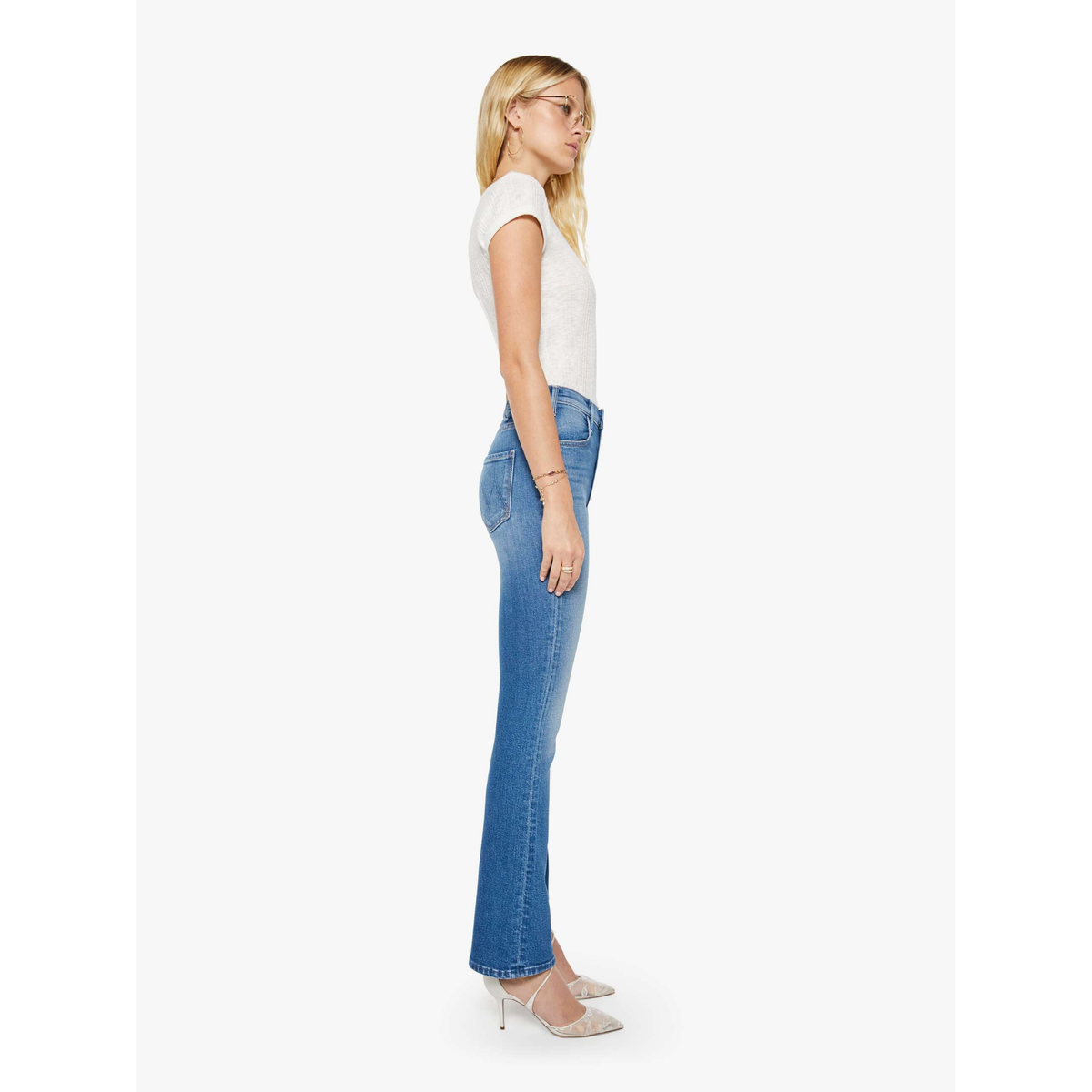 Woman wearing blue jeans and a white top on a white background