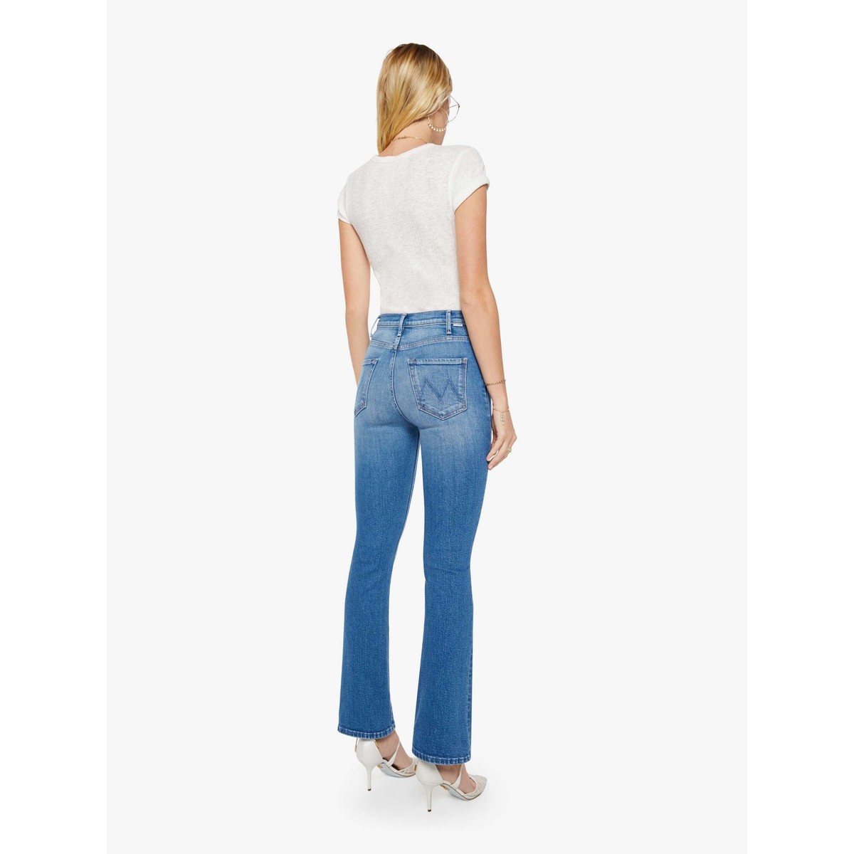 Woman wearing blue jeans and a white top on a white background