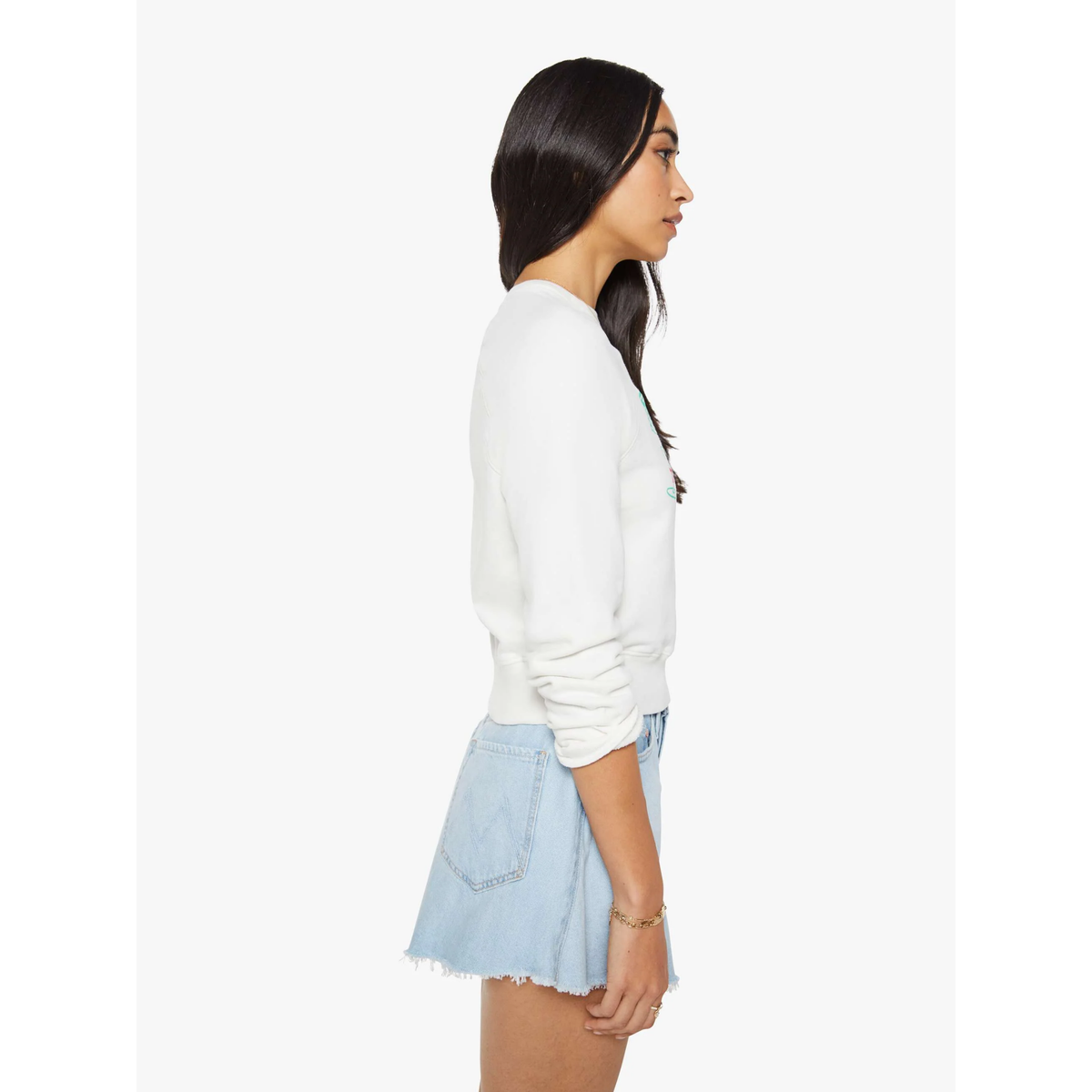Woman wearing a white sweater and light blue denim skirt on a white background