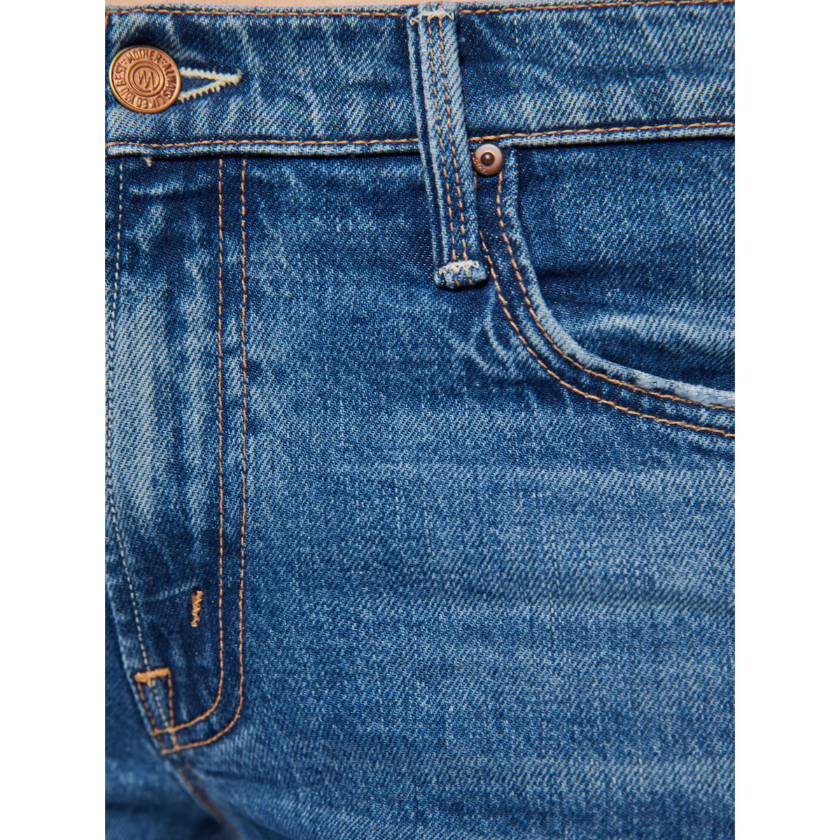 Close-up of blue denim jeans with stitching details on a white background