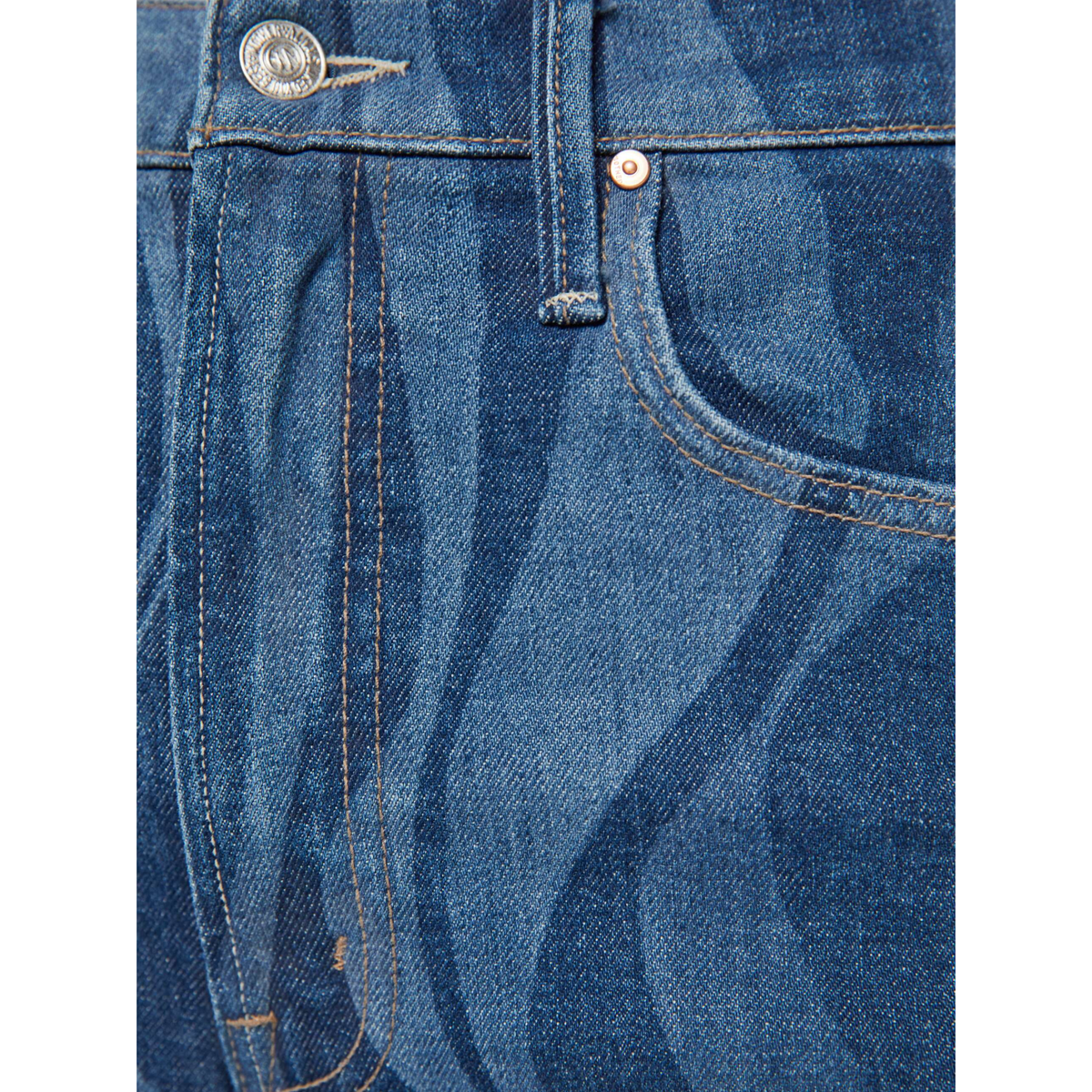 Close-up of blue denim fabric with stitching details on a white background
