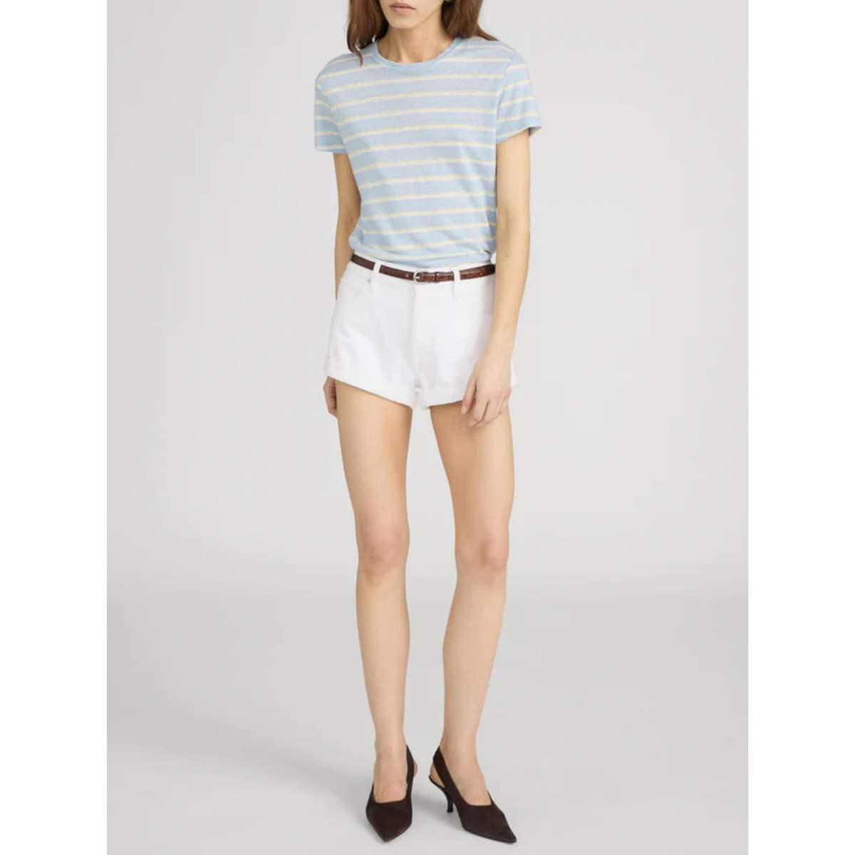 Person wearing a striped shirt and white shorts on a plain background