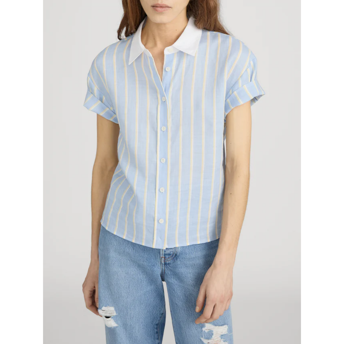Person wearing a light blue and white striped shirt with a plain background