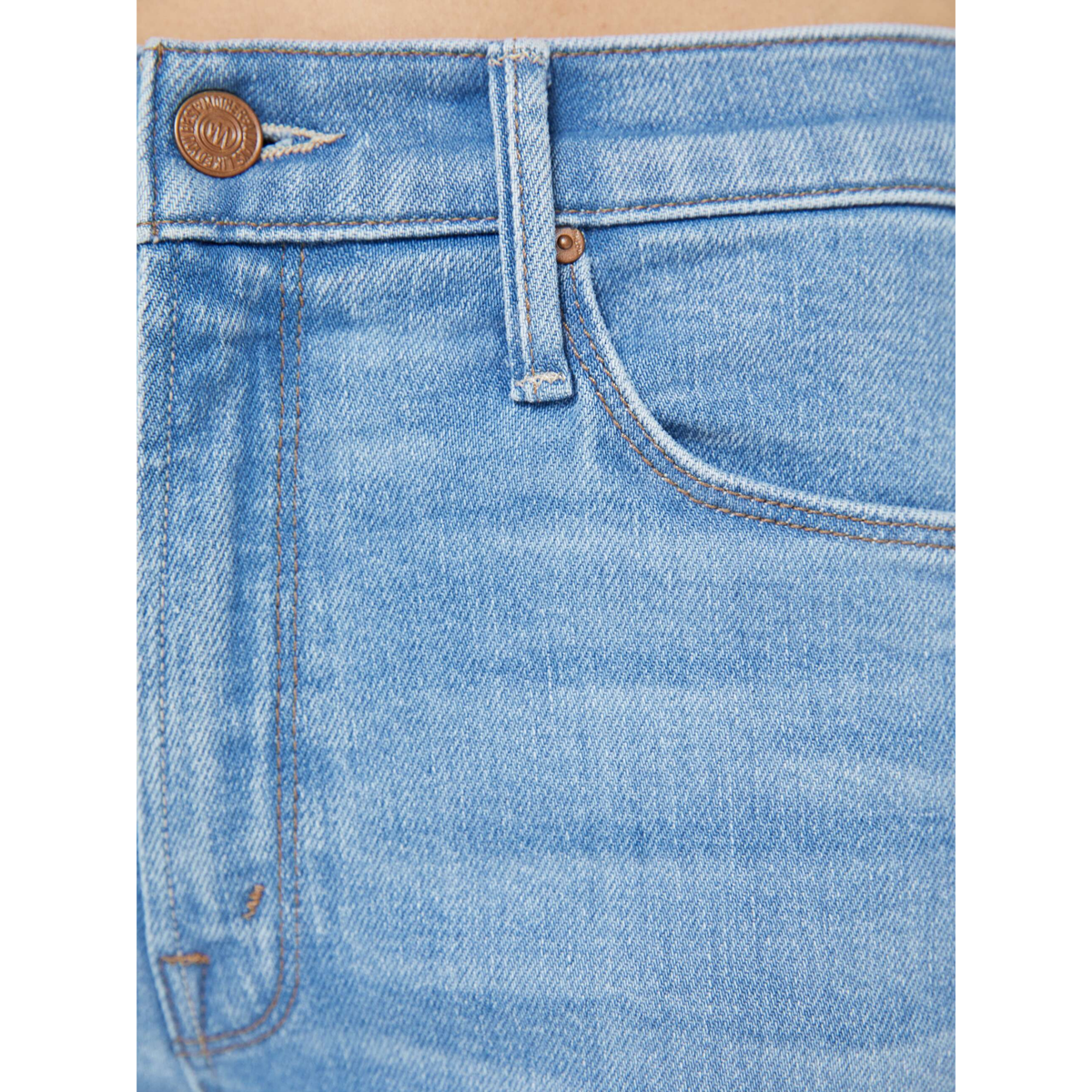 Close-up of blue denim jeans with stitching details on a white background