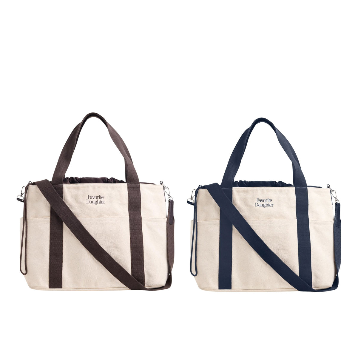 Two canvas tote bags shown side by side on a plain white background. The left bag is cream with dark brown handles and strap, and the right bag is cream with dark navy handles and strap.