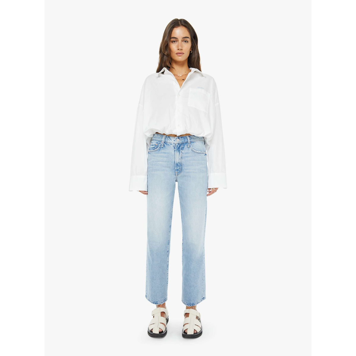 Woman wearing a white shirt and light blue jeans on a white background