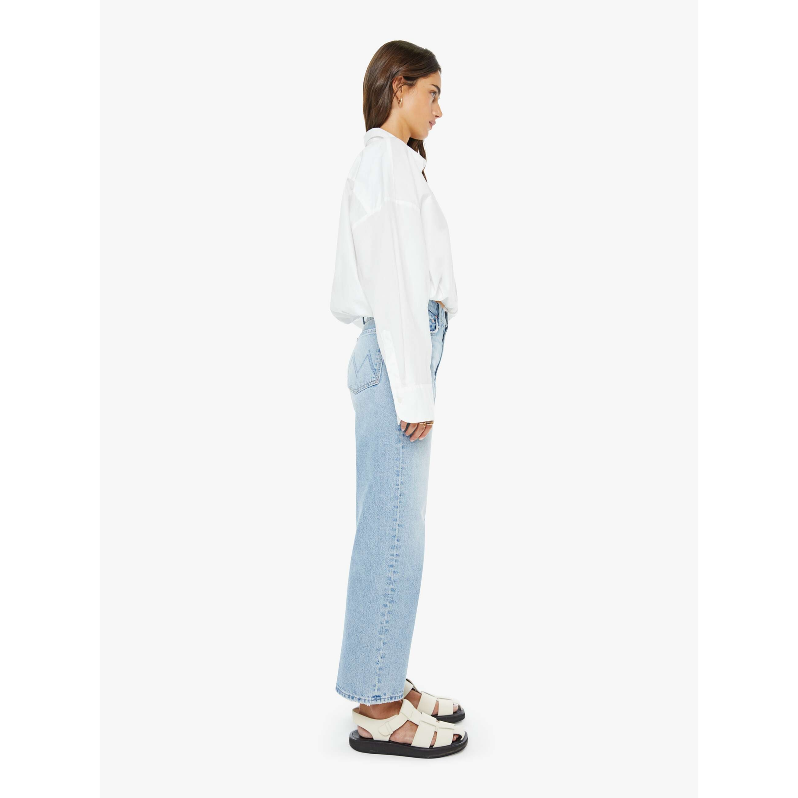 Woman wearing a white shirt and light blue jeans on a white background
