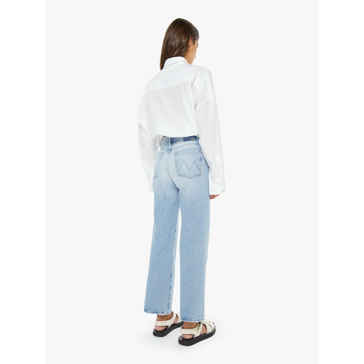 Person wearing light blue jeans and a white shirt on a white background
