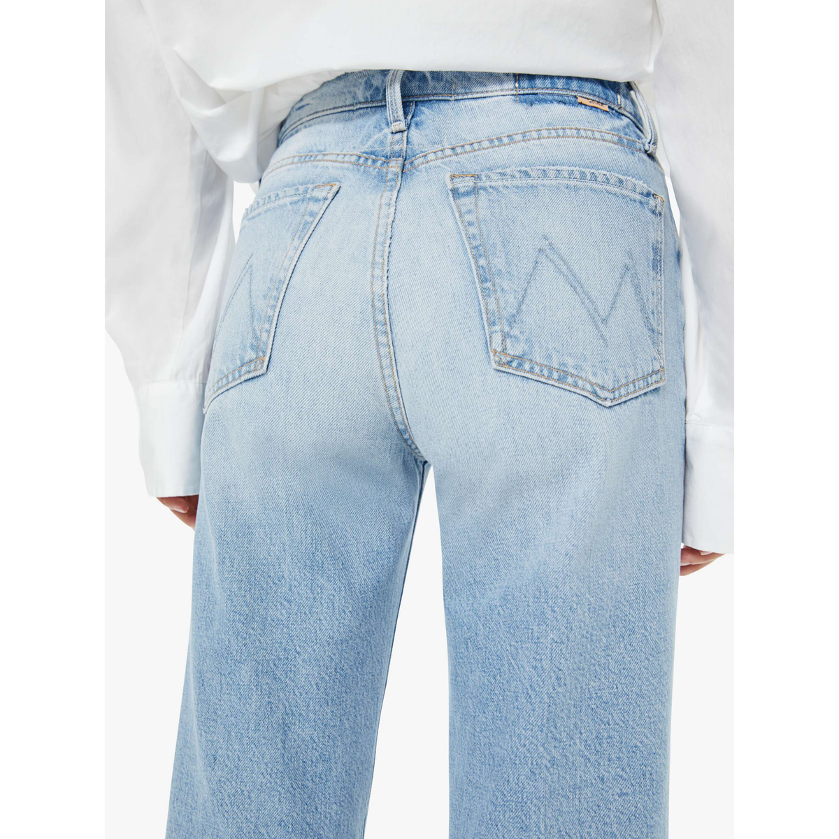 Light blue jeans worn with a white shirt on a white background