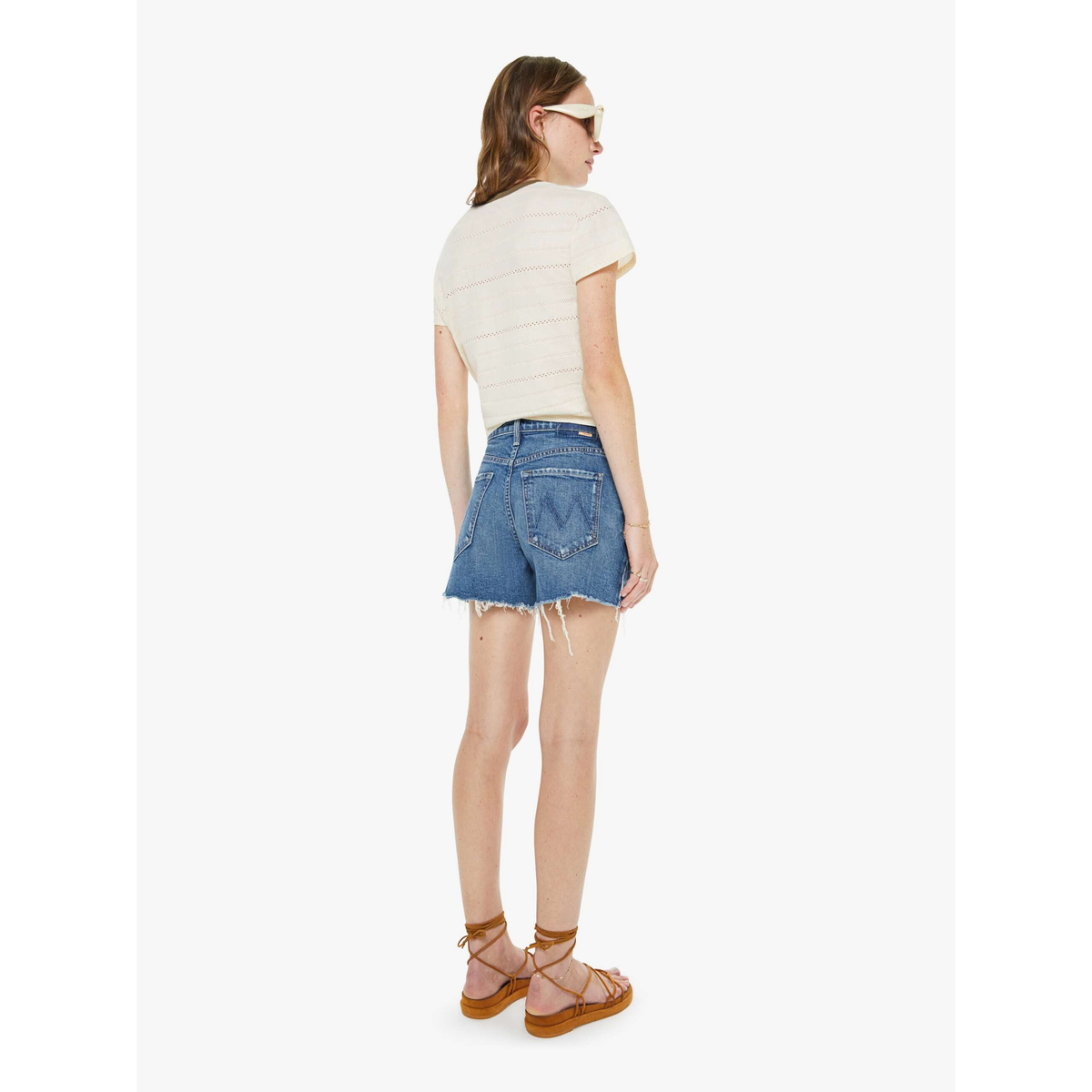 Woman wearing a white t-shirt and blue denim shorts on a white background