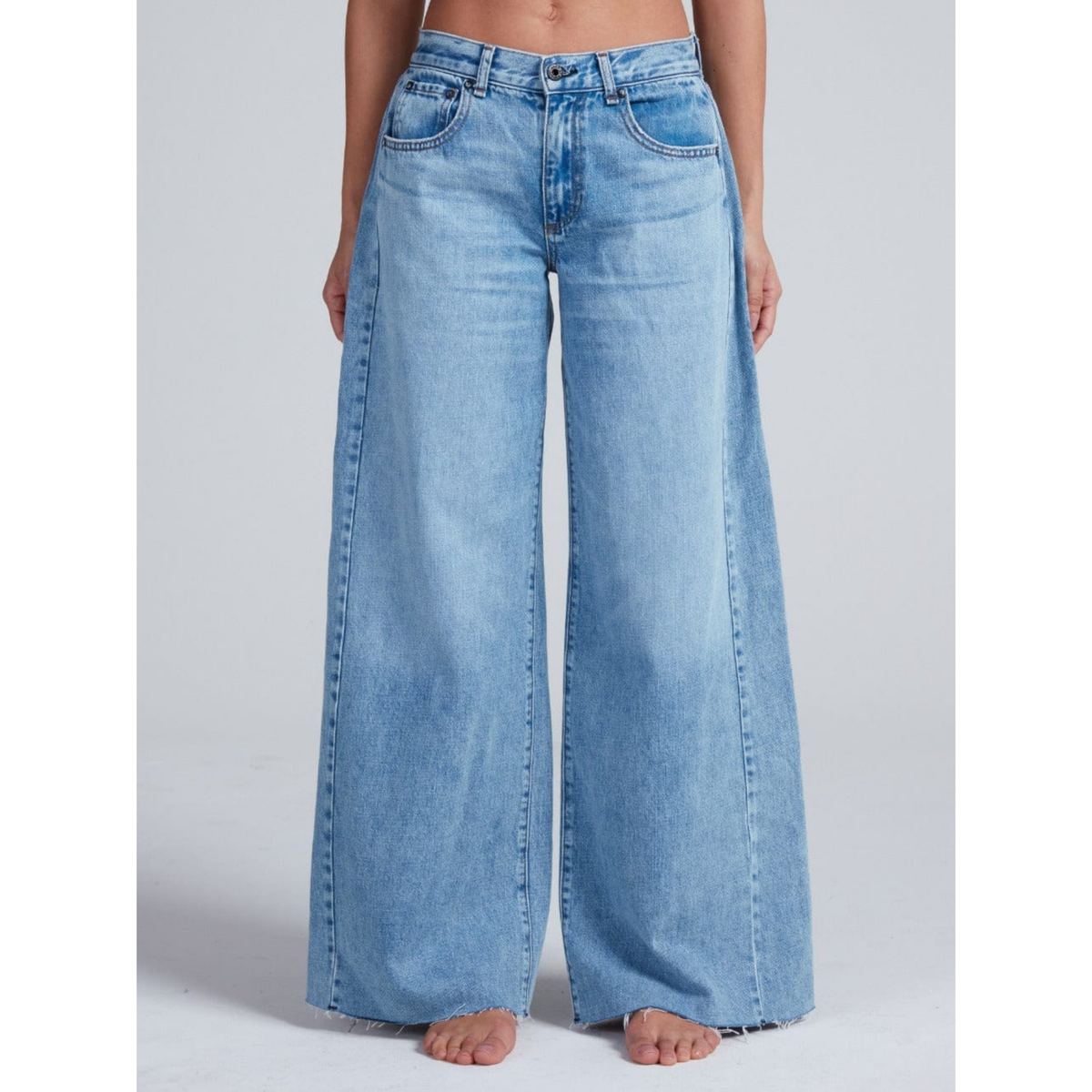Light blue wide-leg jeans worn by a person on a light gray background