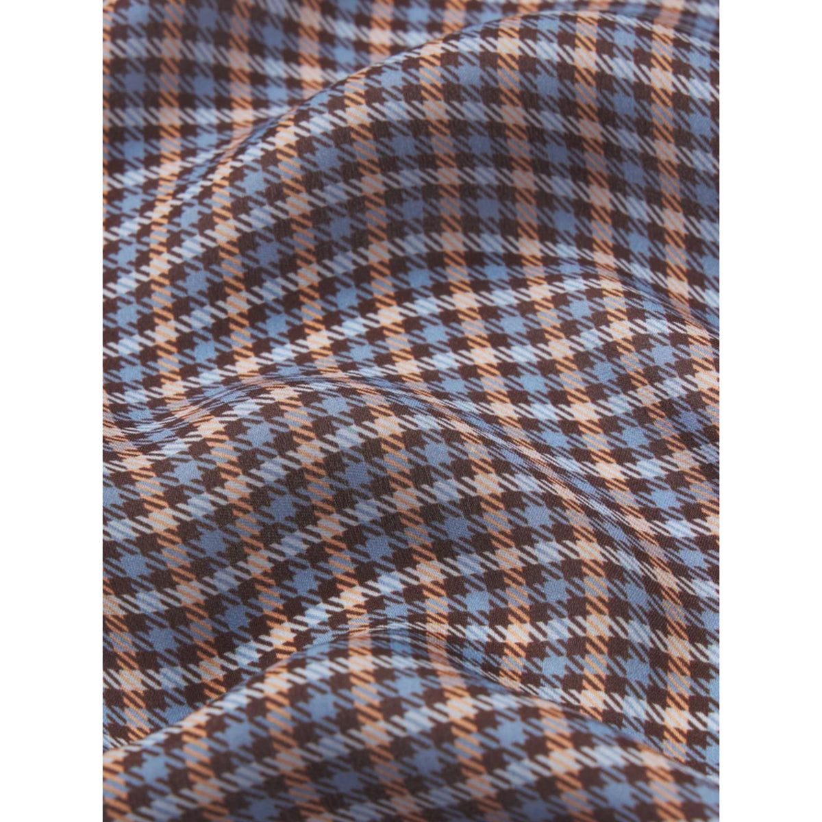 A close-up of a draped fabric with a houndstooth pattern in blue, brown, and beige.