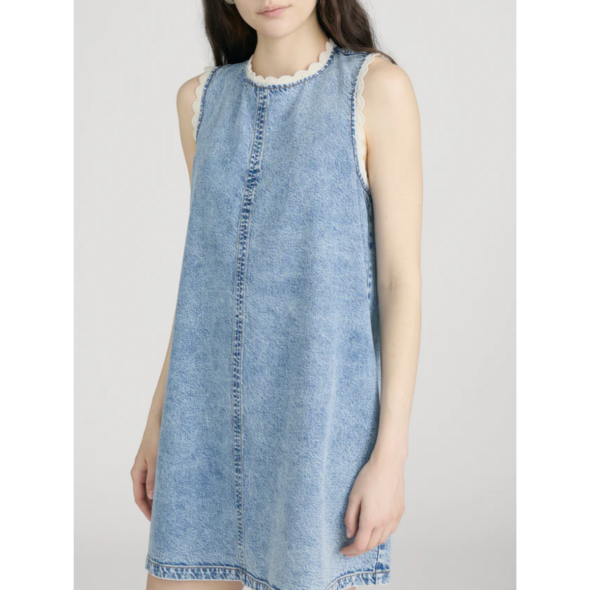 Light blue denim dress with white lace trim on a plain background