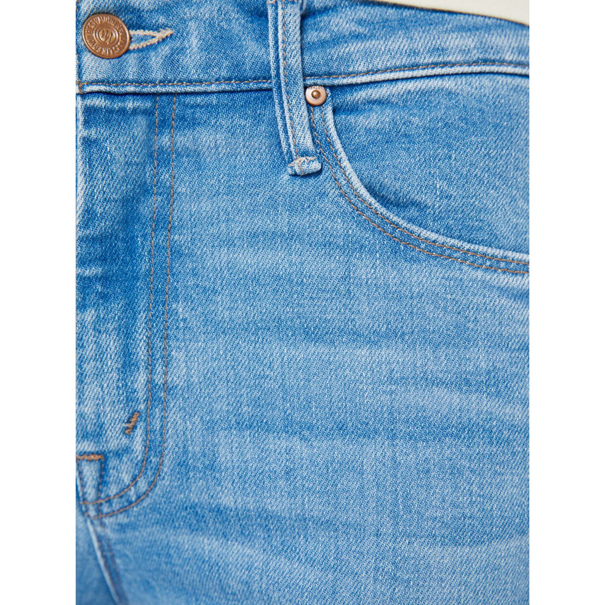 Close-up of blue denim jeans with stitching details on a white background