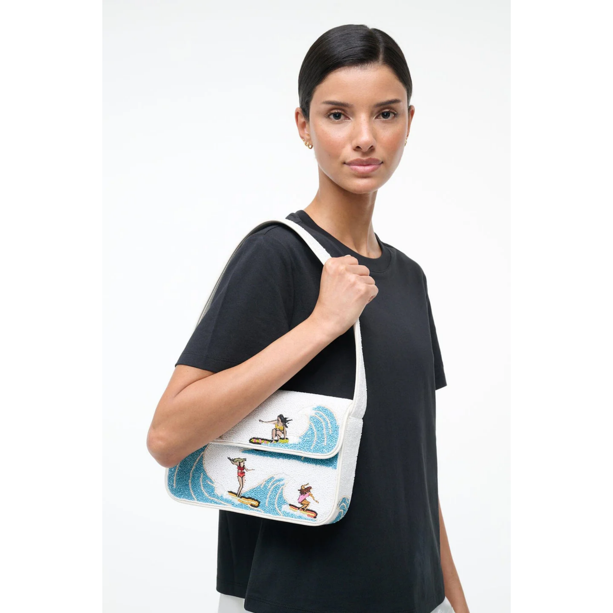Woman holding a white bag with blue designs on a white background