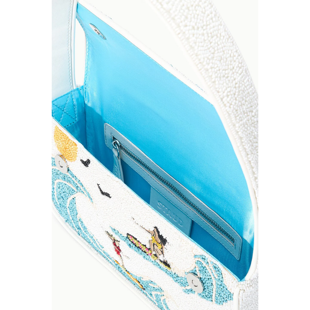 Close-up of a shoe with a design of people on a beach and ocean waves.