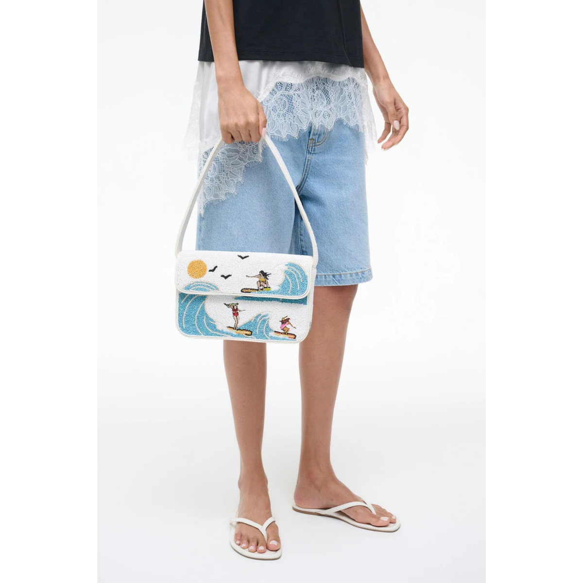 Person holding a tote bag with a beach design on a white background