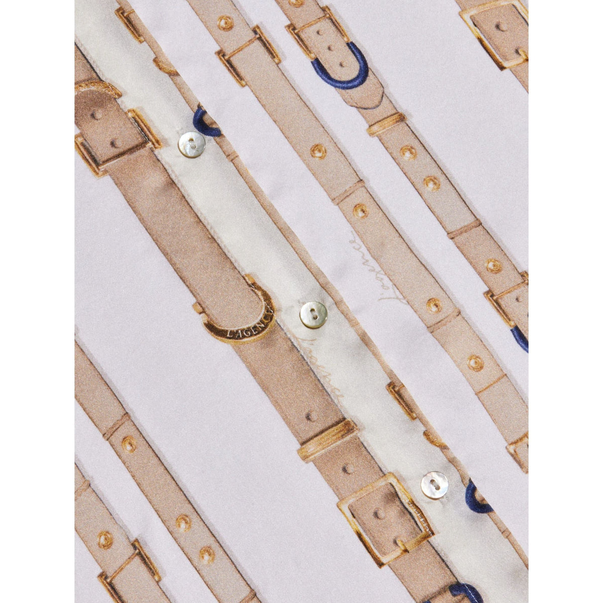 A close-up of a light beige and white fabric featuring a repeating pattern of faux leather straps, buckles, studs, and a small blue accent.