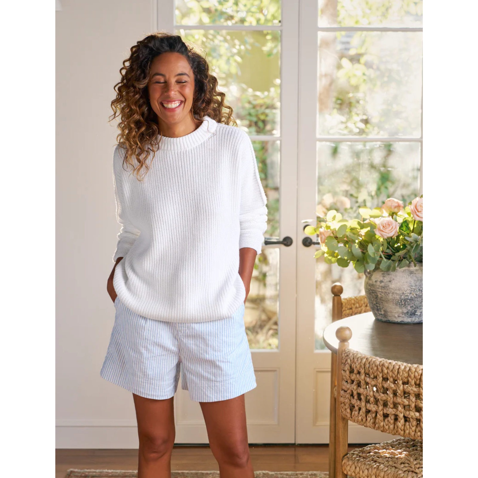 Person wearing light blue striped shorts with a white background