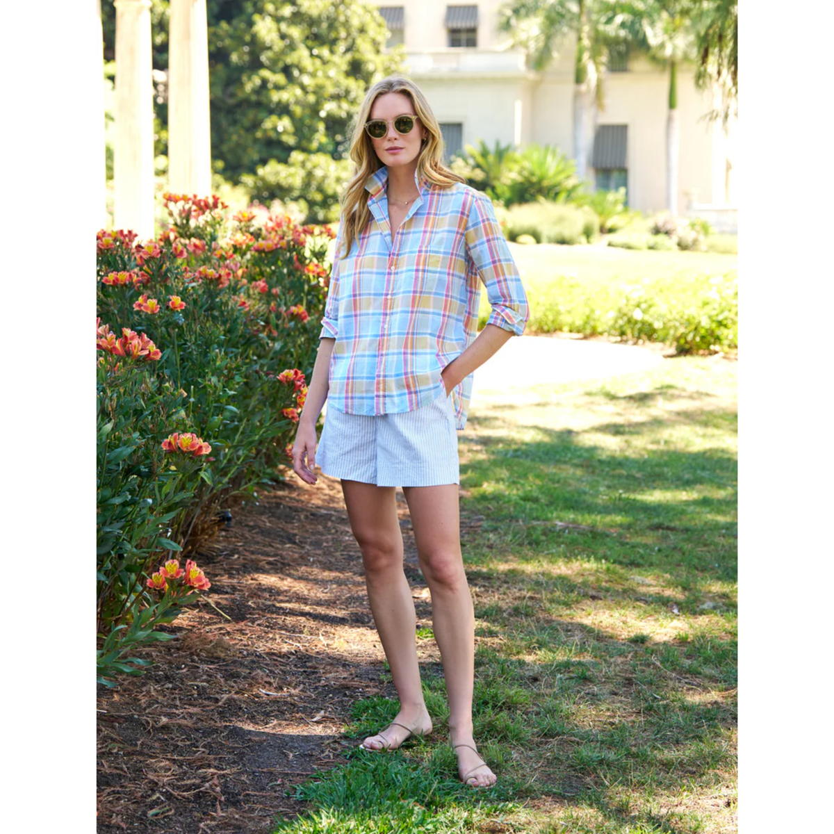 Woman in a plaid shirt and shorts standing in a garden