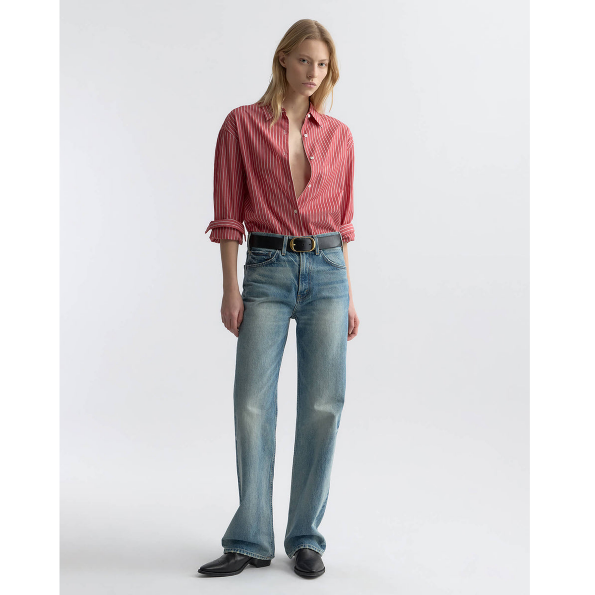 Person wearing a red striped shirt and blue jeans on a white background
