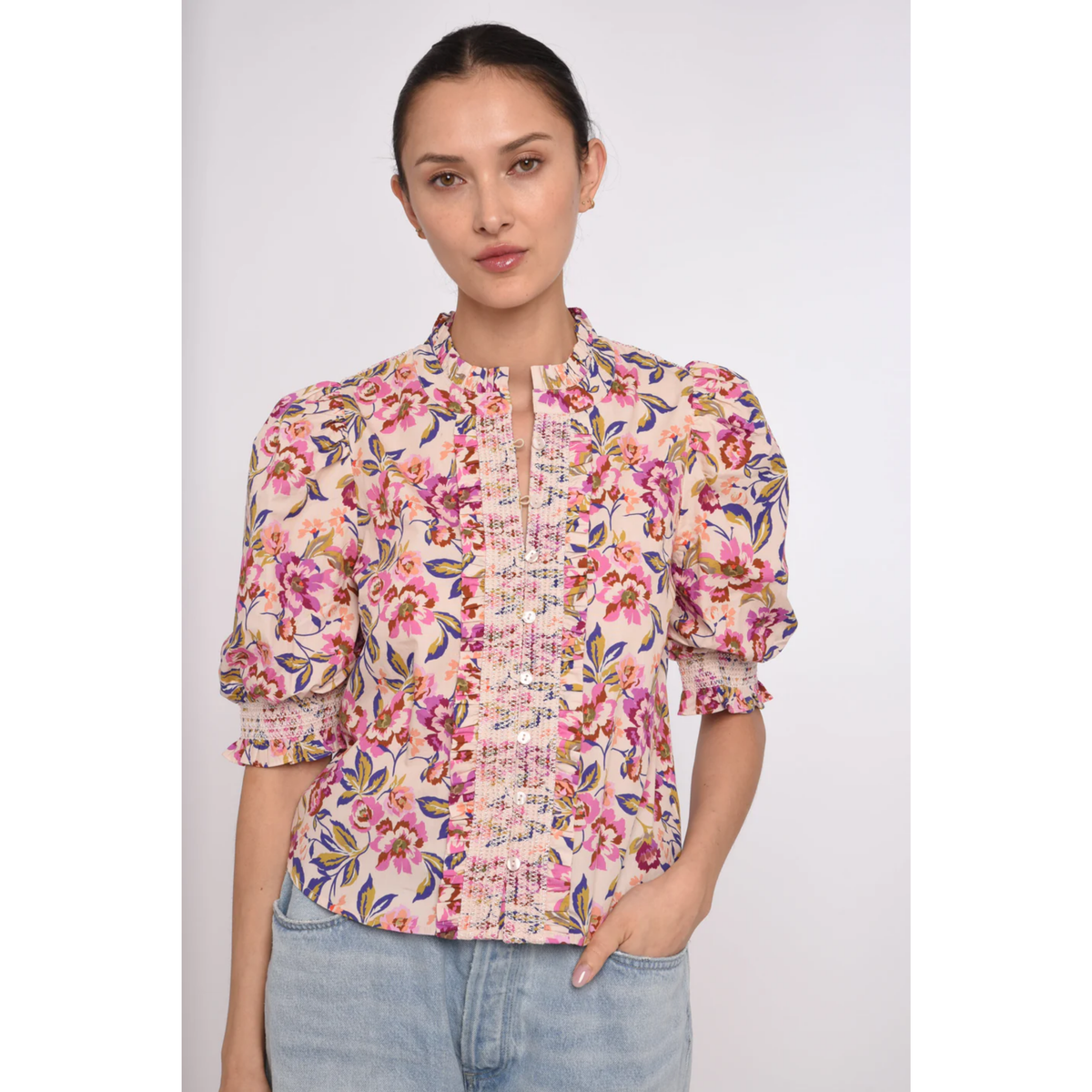 Woman wearing a floral blouse with a plain background