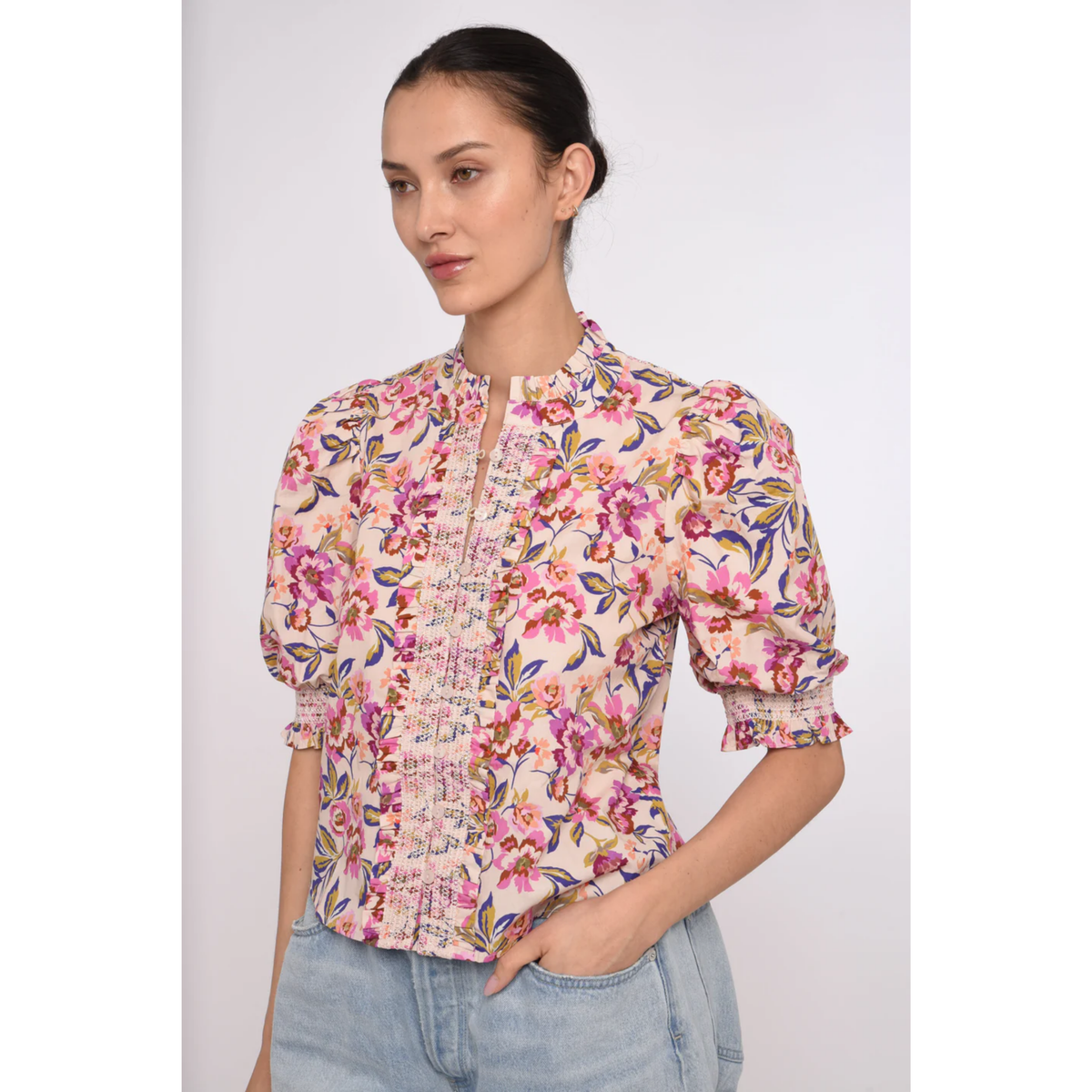 Woman wearing a floral blouse with a plain background