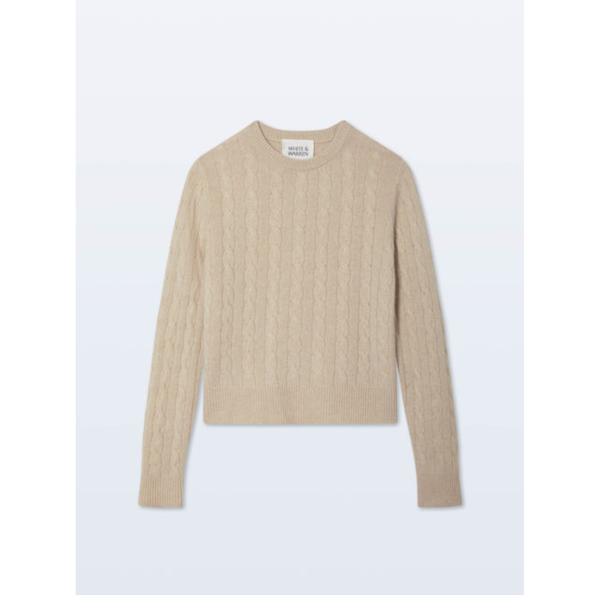 A beige cable-knit cropped sweater with long sleeves, laid flat against a light gray background.
