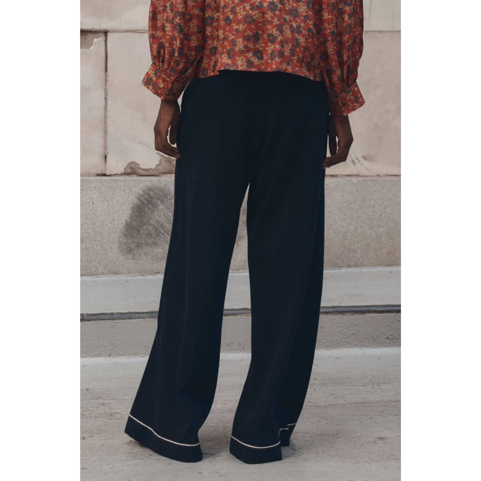 A pair of dark navy blue lounge pants with white contrast piping along the pocket edges and hem, shown flat against a white background.